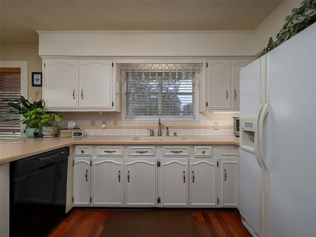a kitchen with white cabinets and white appliances