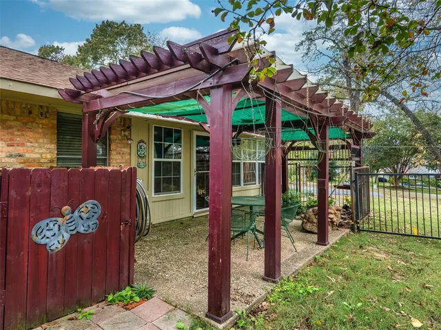 a view of a patio with table and chairs under an umbrella
