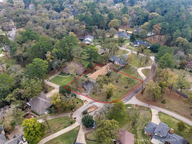 an aerial view of a house with a yard and lake view
