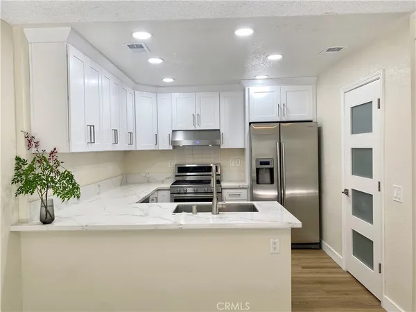 a kitchen with stainless steel appliances a refrigerator sink and cabinets
