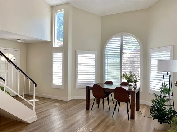 a dining room with furniture potted plants and wooden floor