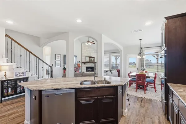 a living room with granite countertop a sink and a refrigerator