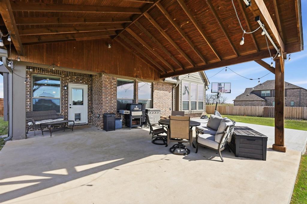 3120 Jessup Circle Blue Ridge, TX 75424 - Photo 2 of 35 a view of a patio with table and chairs under an umbrella with a barbeque