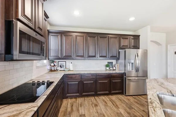 a kitchen with granite countertop stainless steel appliances and wooden cabinets