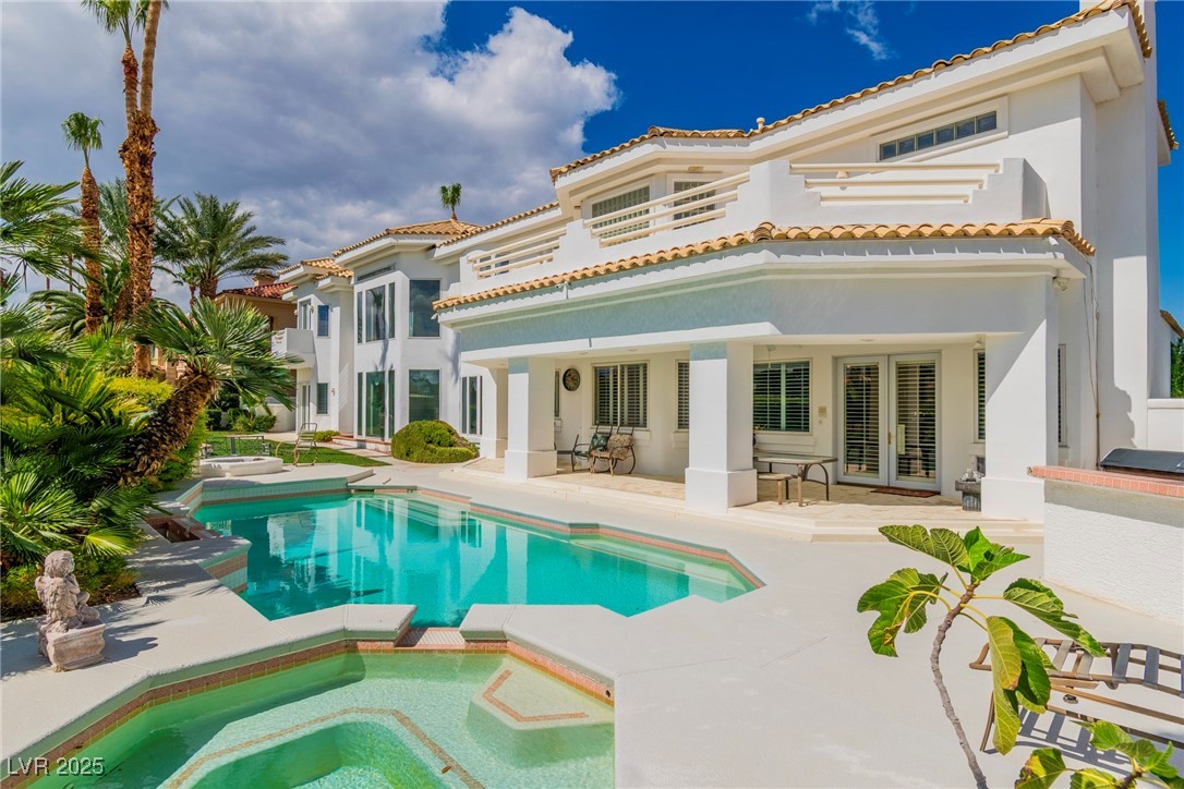 23 Cascade Creek Lane Las Vegas, NV 89113 - Photo 18 of 89 Rear view of house with a patio area, stucco siding, a pool with connected hot tub, and a tile roof