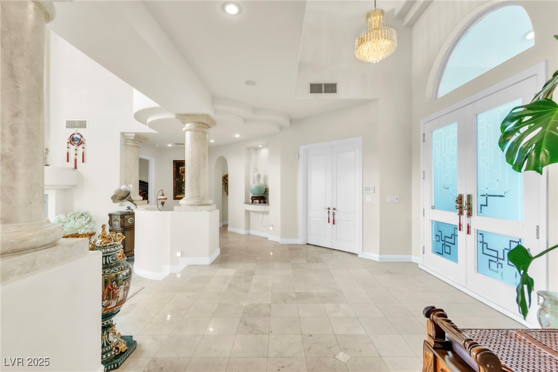 23 Cascade Creek Lane Las Vegas, NV 89113 - Photo 23 of 89 Entryway featuring french doors, decorative columns, recessed lighting, light tile patterned flooring, and a towering ceiling