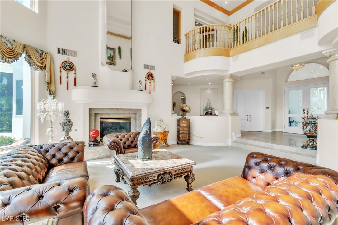 23 Cascade Creek Lane Las Vegas, NV 89113 - Photo 35 of 89 Living room with ornate columns, a high end fireplace, a towering ceiling, and french doors