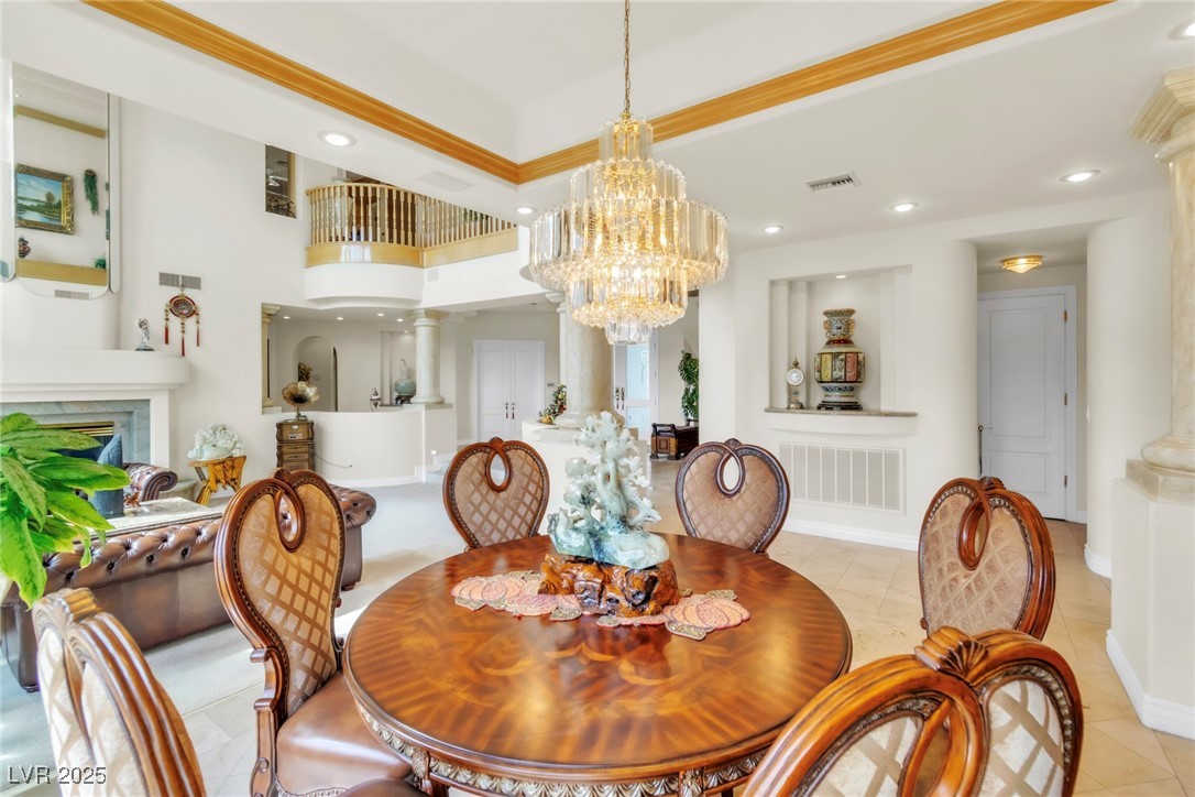 23 Cascade Creek Lane Las Vegas, NV 89113 - Photo 40 of 89 Dining room with ornate columns, a chandelier, recessed lighting, a raised ceiling, and light tile patterned flooring