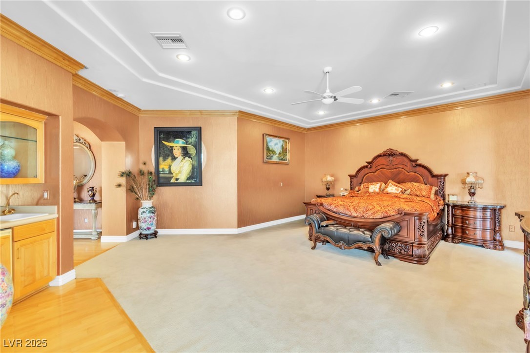 23 Cascade Creek Lane Las Vegas, NV 89113 - Photo 76 of 89 Bedroom with crown molding, recessed lighting, light wood-style flooring, arched walkways, and a tray ceiling