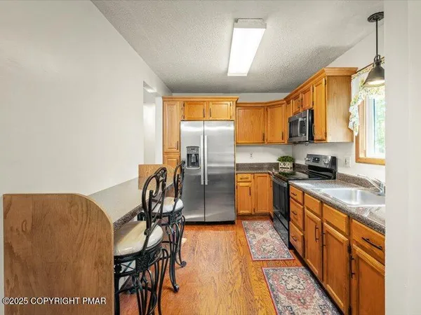 a kitchen with stainless steel appliances granite countertop a refrigerator a stove top oven a sink and dishwasher