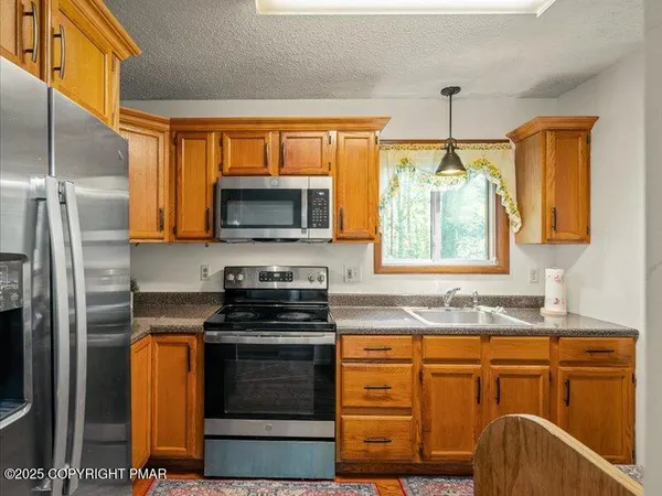 a kitchen with granite countertop a sink stainless steel appliances and cabinets