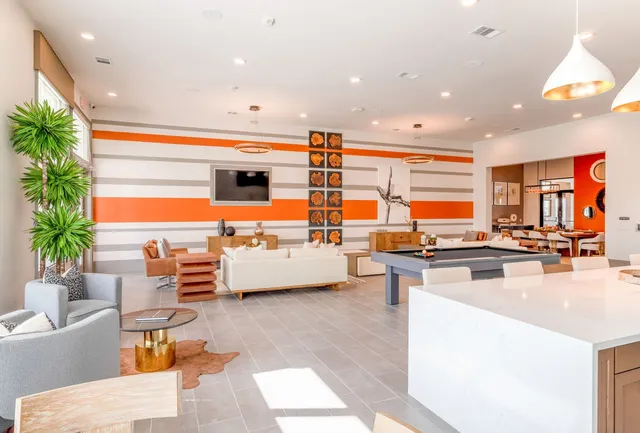 a kitchen with stainless steel appliances kitchen island granite countertop a living room and couches with wooden floor