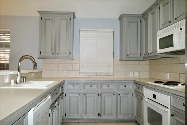 a kitchen with granite countertop white cabinets and stainless steel appliances