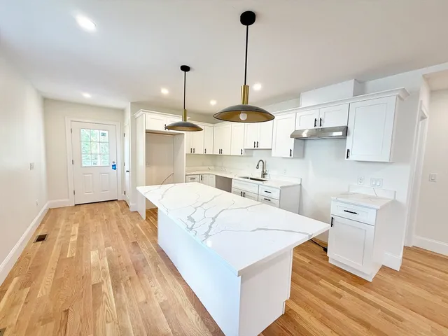 a large kitchen with kitchen island a stove a sink dishwasher and a wooden cabinets