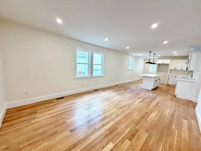 a view of empty room with wooden floor and window