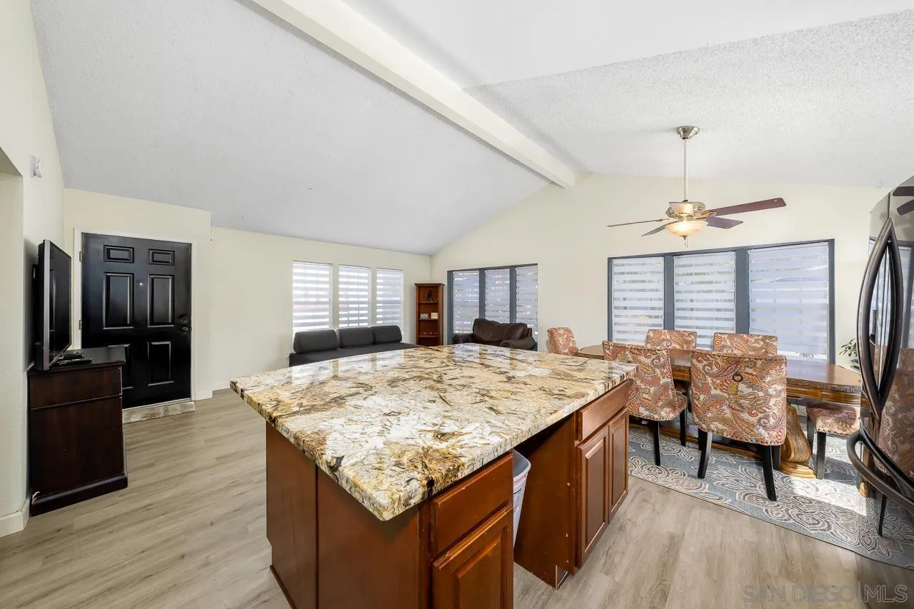 15935 Spring Oaks Road, Unit 201 El Cajon, CA 92021 - Photo 13 of 32 a open kitchen with stainless steel appliances granite countertop table chairs and granite counter tops