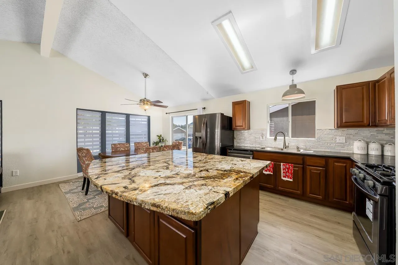 15935 Spring Oaks Road, Unit 201 El Cajon, CA 92021 - Photo 14 of 32 a kitchen with granite countertop cabinets a sink dishwasher and a stove with wooden floor