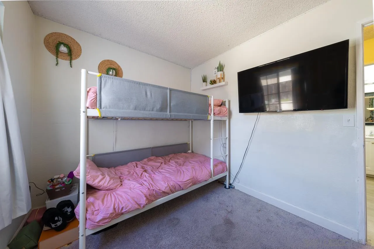 15935 Spring Oaks Road, Unit 201 El Cajon, CA 92021 - Photo 18 of 32 a bedroom with a bed and a flat screen tv