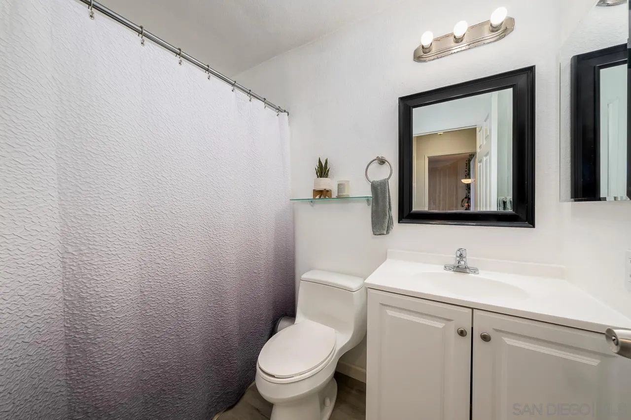15935 Spring Oaks Road, Unit 201 El Cajon, CA 92021 - Photo 20 of 32 a bathroom with a toilet sink and mirror