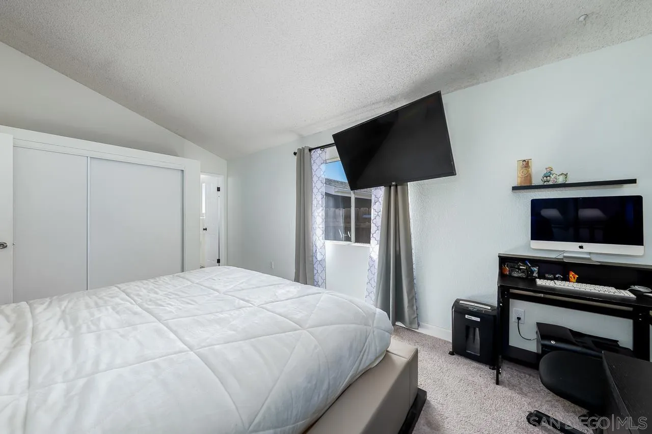 15935 Spring Oaks Road, Unit 201 El Cajon, CA 92021 - Photo 23 of 32 a bedroom with a flat screen tv and a bed