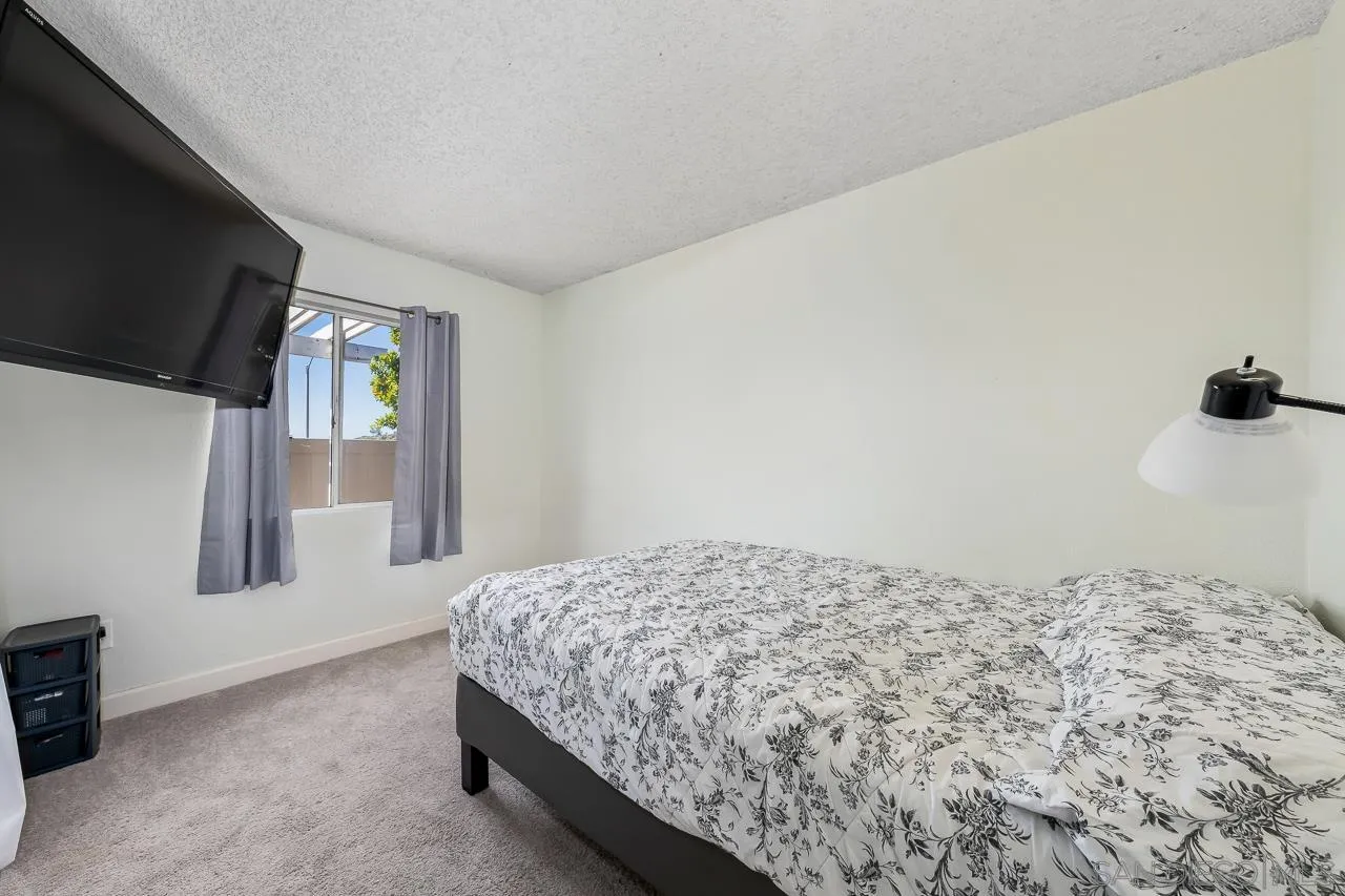 15935 Spring Oaks Road, Unit 201 El Cajon, CA 92021 - Photo 25 of 32 a bedroom with a bed and a flat screen tv