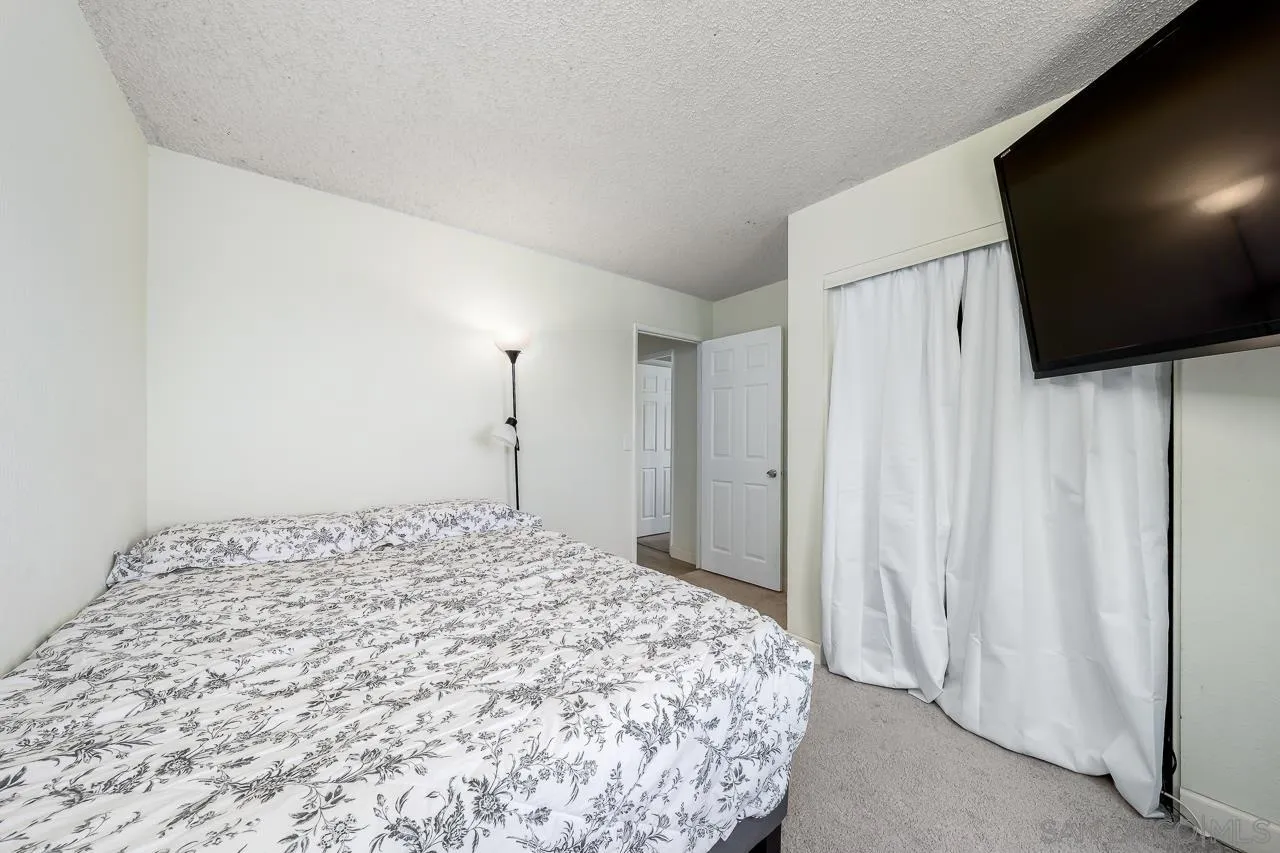 15935 Spring Oaks Road, Unit 201 El Cajon, CA 92021 - Photo 26 of 32 a bedroom with a bed and a flat screen tv