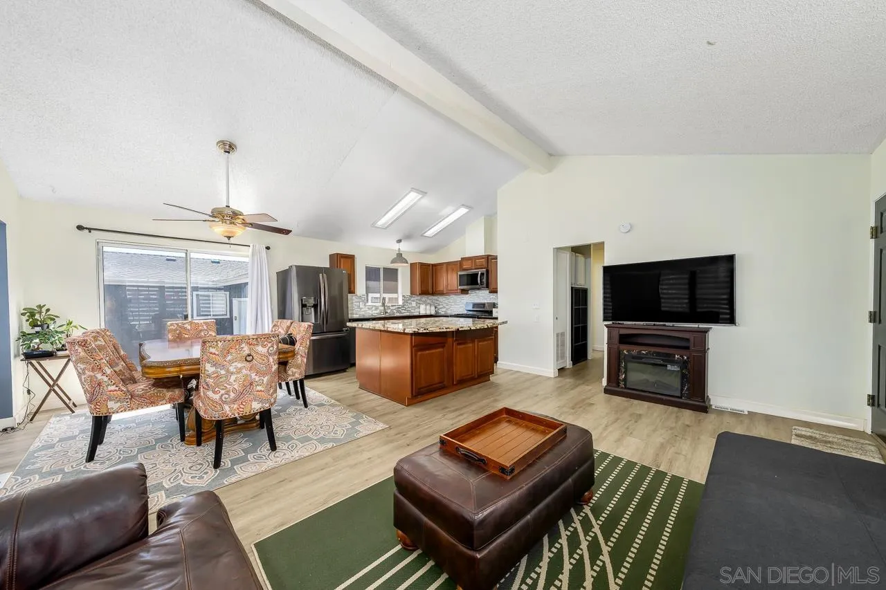 15935 Spring Oaks Road, Unit 201 El Cajon, CA 92021 - Photo 7 of 32 a living room with furniture a flat screen tv and kitchen view