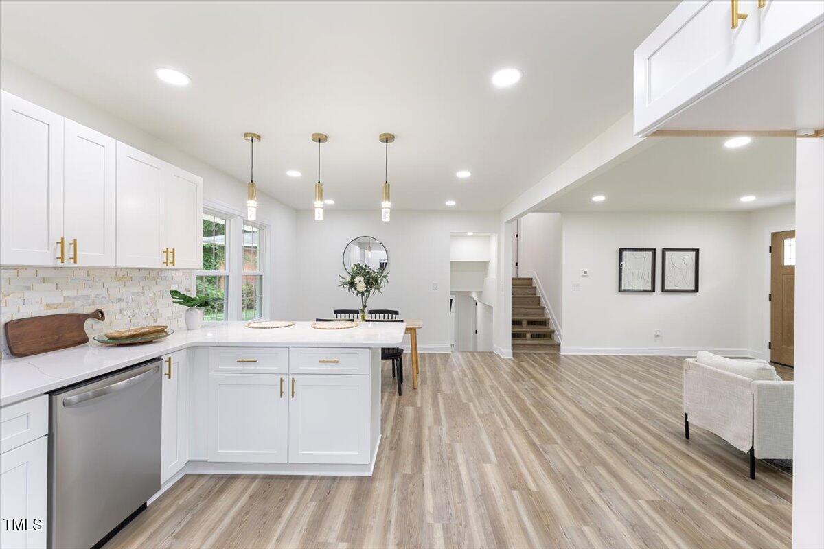 3420 Brentwood Road Raleigh, NC 27604 - Photo 17 of 53 a large white kitchen with a lot of counter space and wooden floor