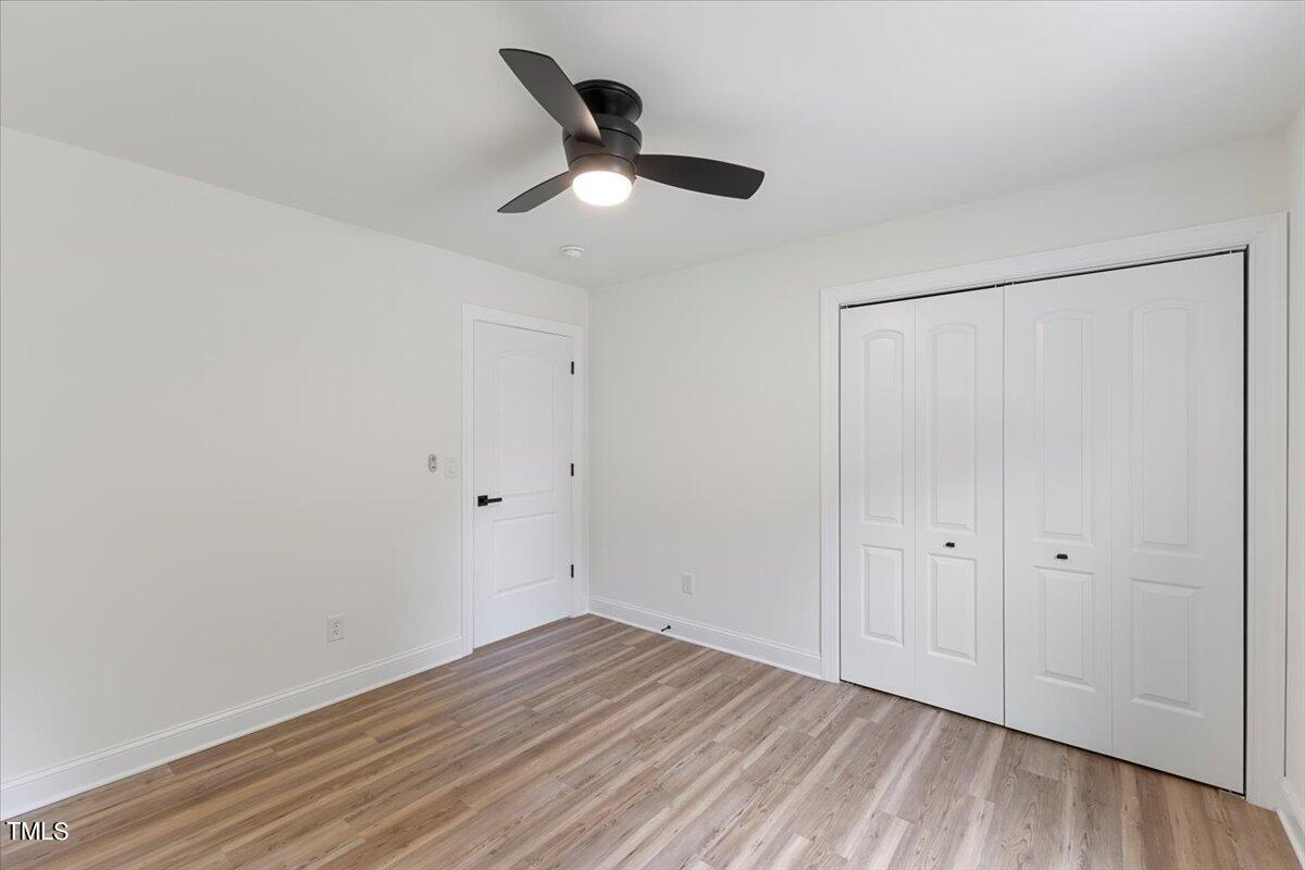 3420 Brentwood Road Raleigh, NC 27604 - Photo 42 of 53 an empty room with wooden floor cabinet and windows