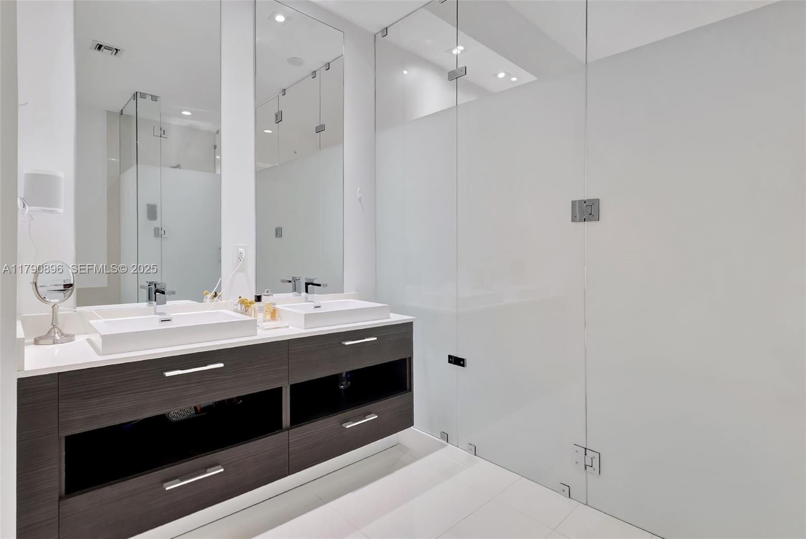55 Southwest 9th Street, Unit PH4501 Miami, FL 33130 - Photo 20 of 71 a spacious bathroom with a double vanity sink a large mirror and shower