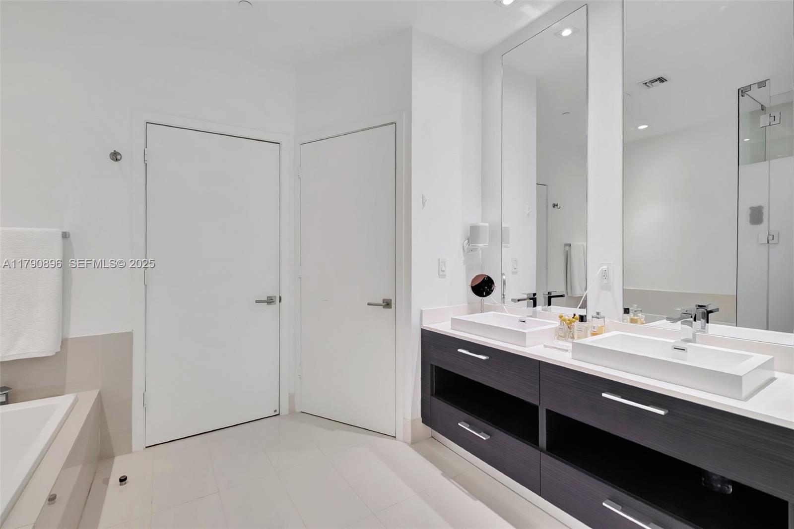 55 Southwest 9th Street, Unit PH4501 Miami, FL 33130 - Photo 21 of 71 a en suite bathroom with a double vanity sink a large mirror and shower