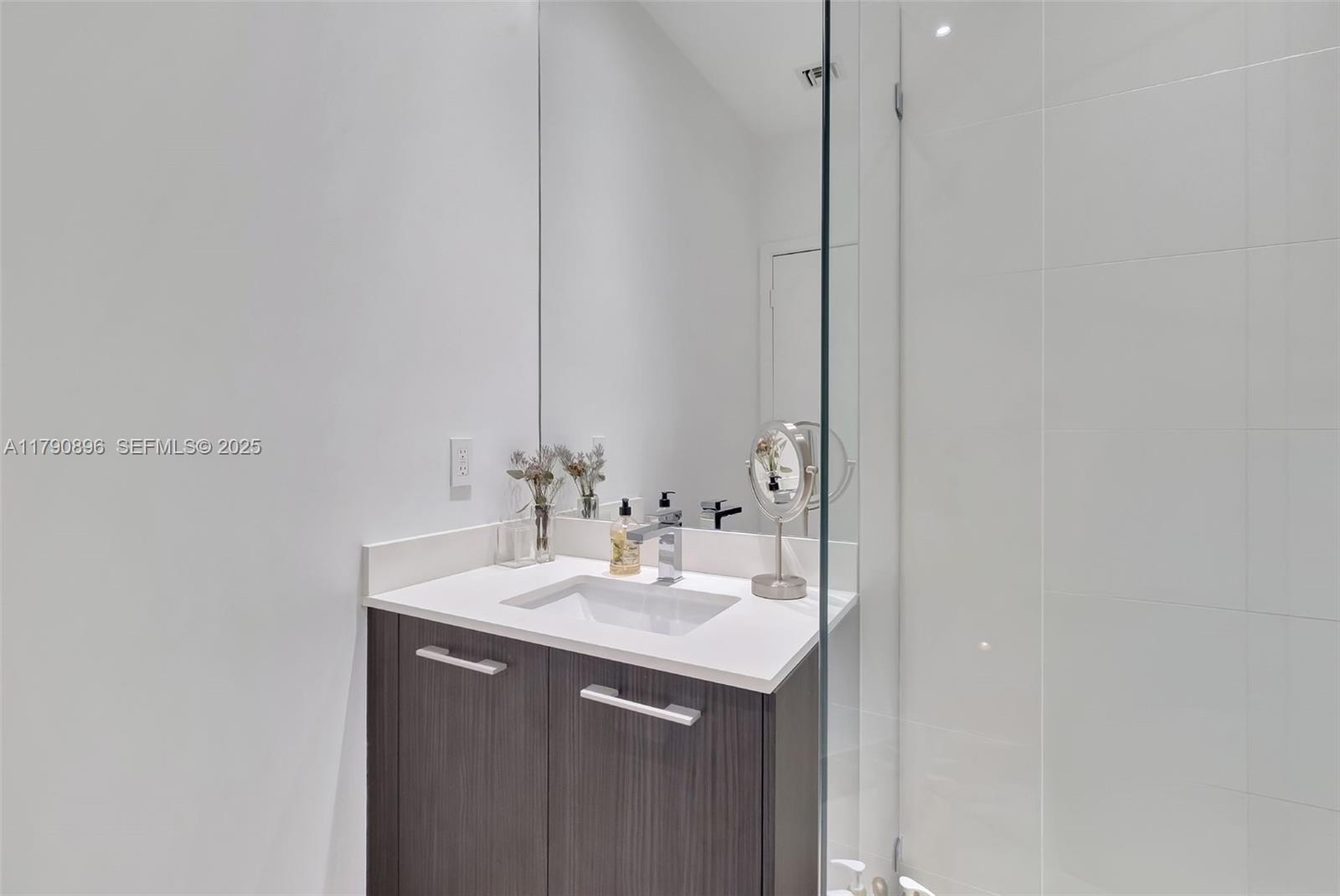 55 Southwest 9th Street, Unit PH4501 Miami, FL 33130 - Photo 31 of 71 a bathroom with a sink and a mirror