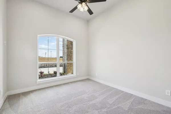 an empty room with fan and windows