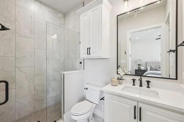 a bathroom with a sink a toilet and shower