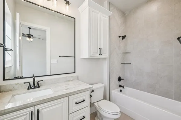 a bathroom with a granite countertop sink toilet and shower