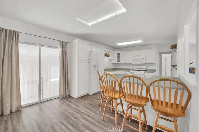 a kitchen with granite countertop white cabinets and white appliances
