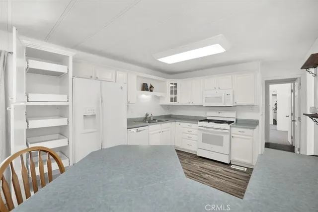 a kitchen with white cabinets and white appliances