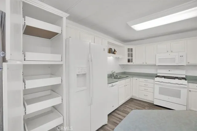 a kitchen with white cabinets and white appliances