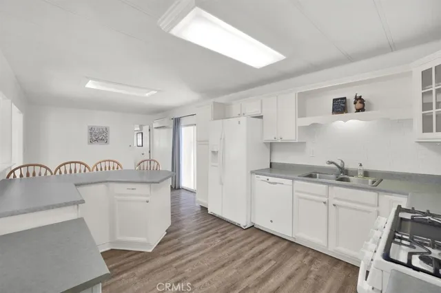 a kitchen with granite countertop a sink stove and refrigerator