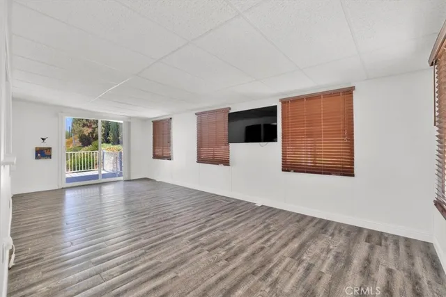 a view of a a dining room with furniture window and wooden floor
