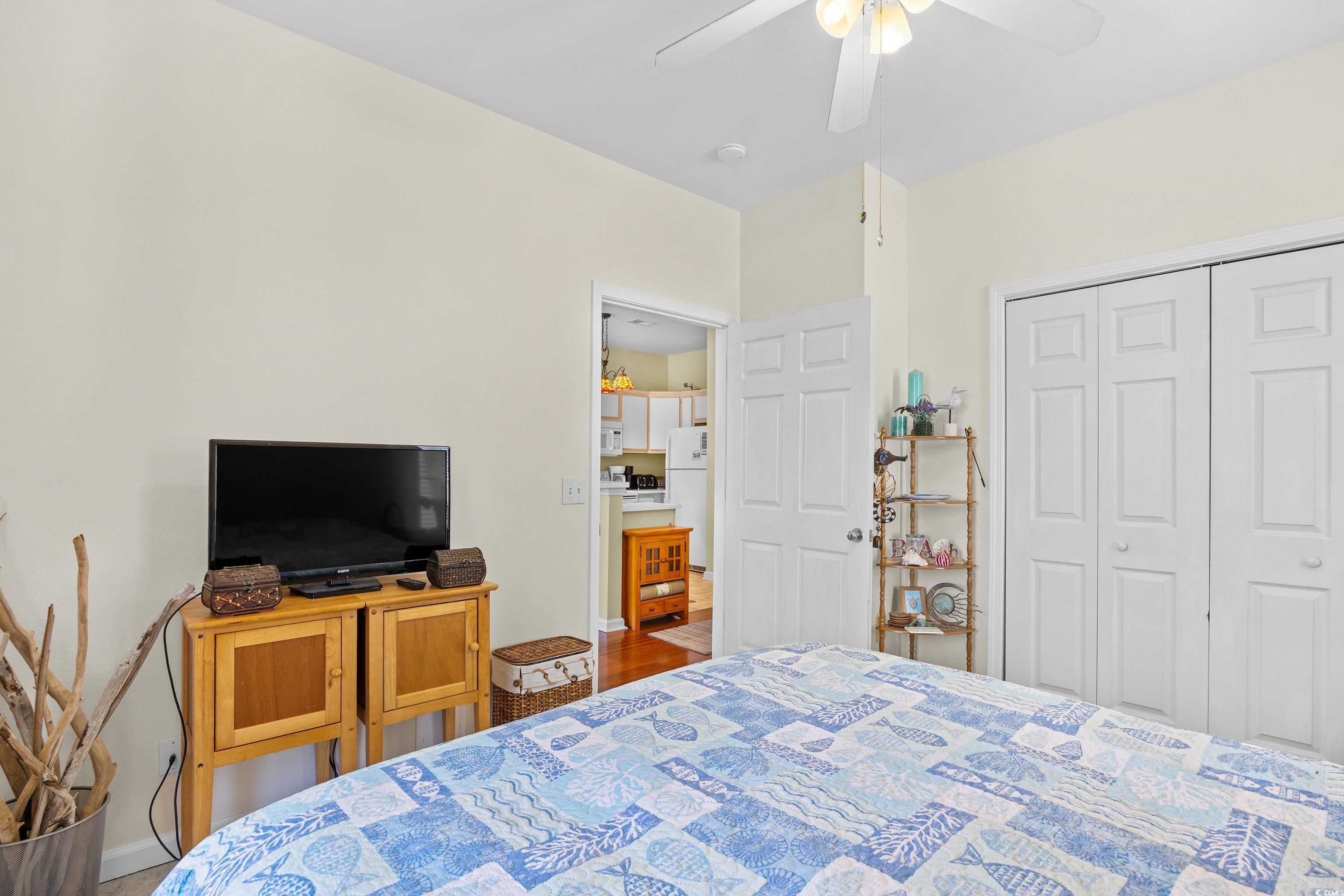 1298 River Oaks Drive, Unit 5J Myrtle Beach, SC 29579 - Photo 19 of 33 Bedroom featuring freestanding refrigerator, a closet, and a ceiling fan