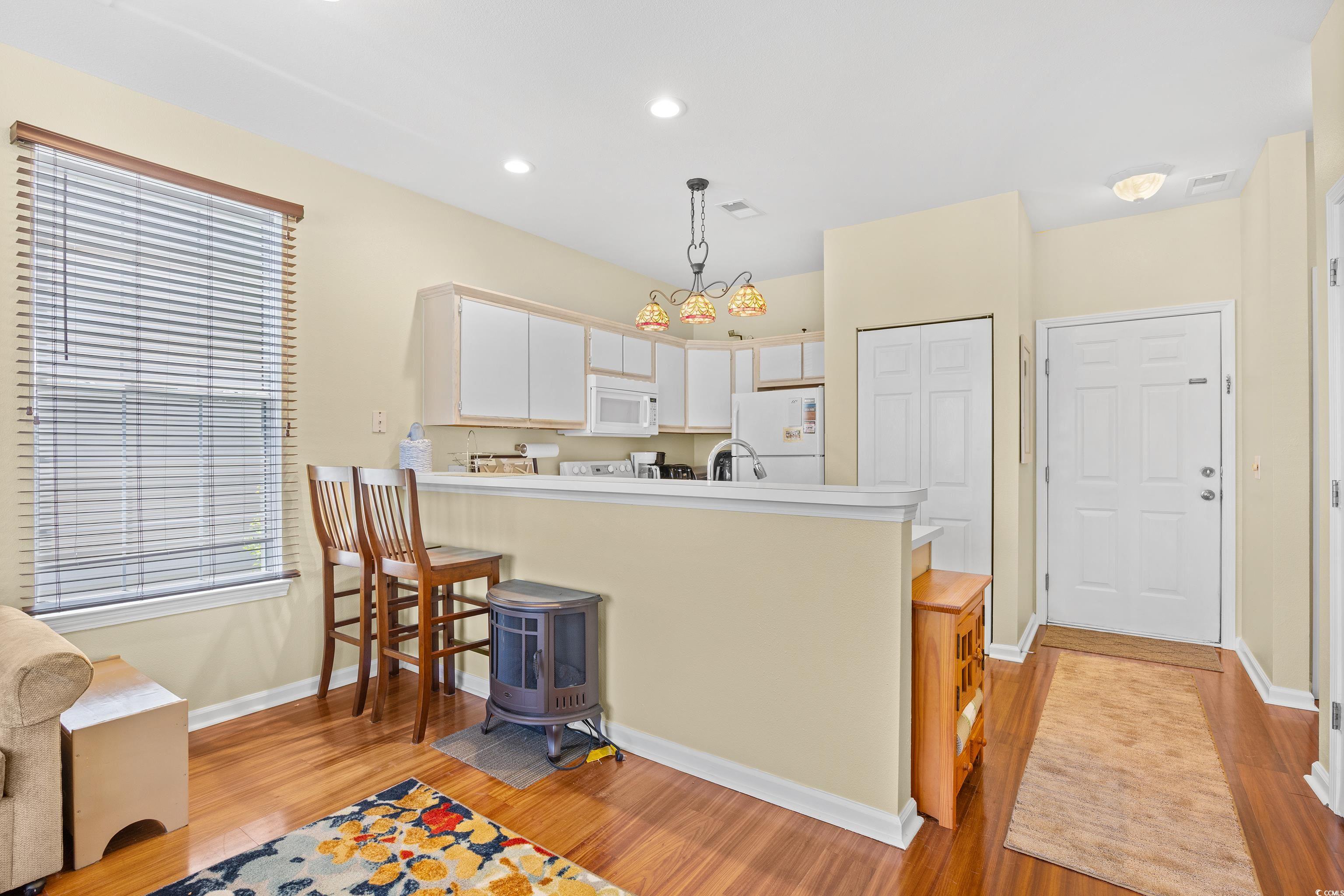 1298 River Oaks Drive, Unit 5J Myrtle Beach, SC 29579 - Photo 3 of 33 Kitchen featuring white appliances, light wood-style flooring, a peninsula, light countertops, and recessed lighting