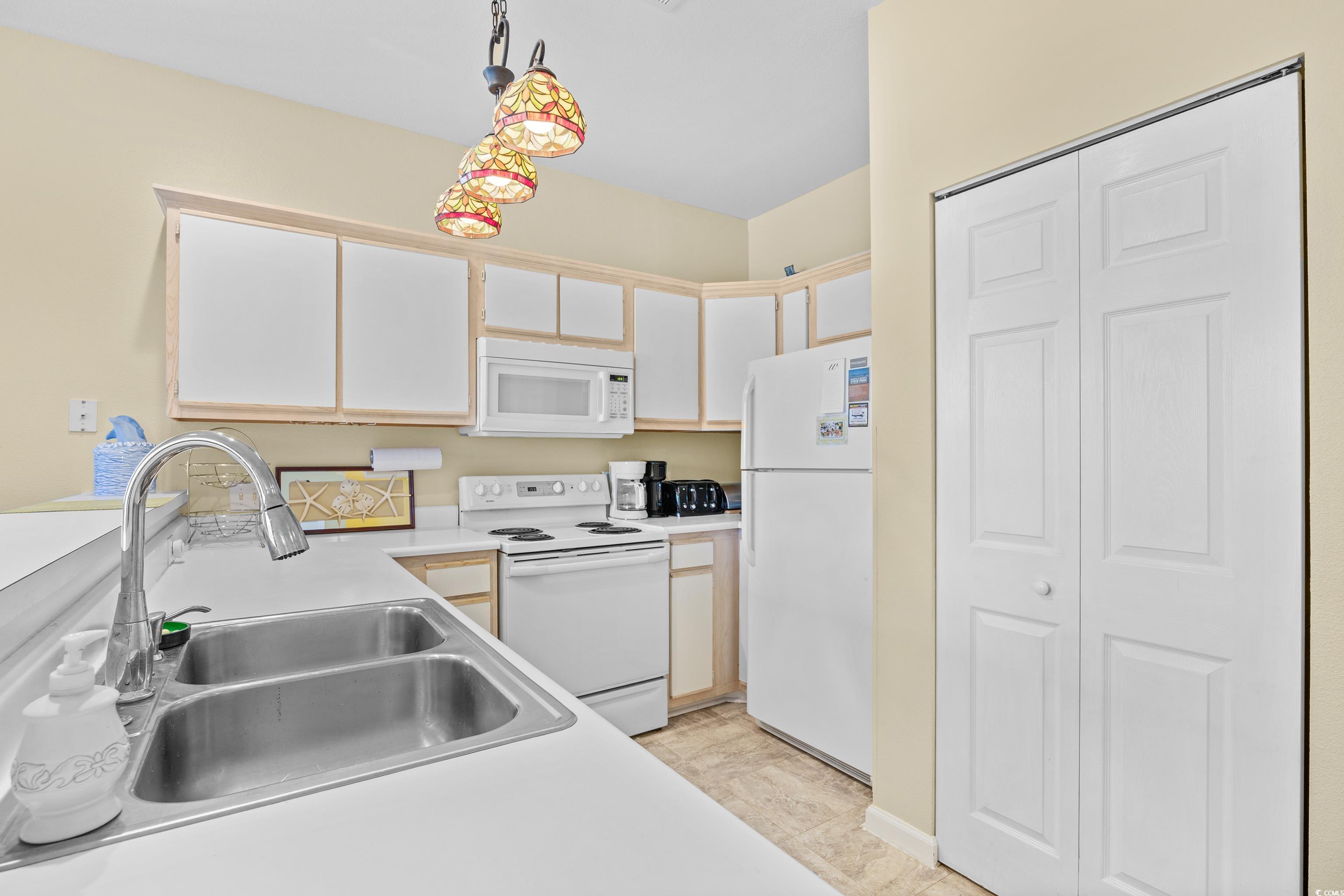 1298 River Oaks Drive, Unit 5J Myrtle Beach, SC 29579 - Photo 4 of 33 Kitchen with white appliances, light countertops, decorative light fixtures, and white cabinets