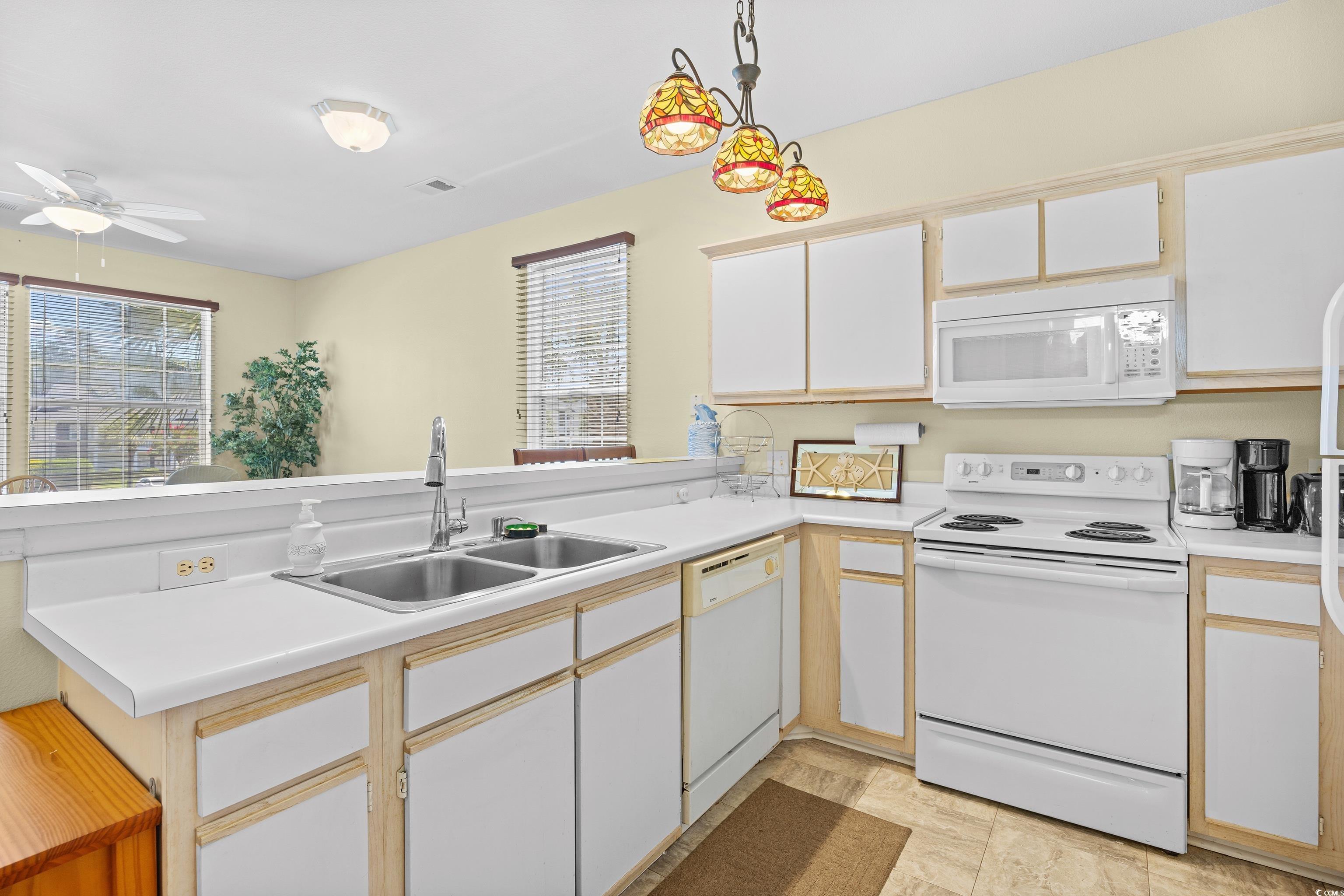 1298 River Oaks Drive, Unit 5J Myrtle Beach, SC 29579 - Photo 6 of 33 Kitchen featuring white appliances, a ceiling fan, light countertops, and decorative light fixtures