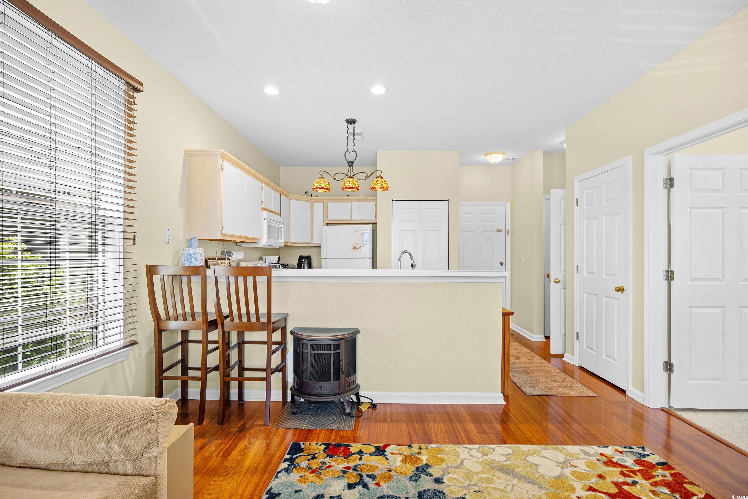 1298 River Oaks Drive, Unit 5J Myrtle Beach, SC 29579 - Photo 8 of 33 Kitchen featuring white appliances, light wood finished floors, a peninsula, recessed lighting, and light countertops