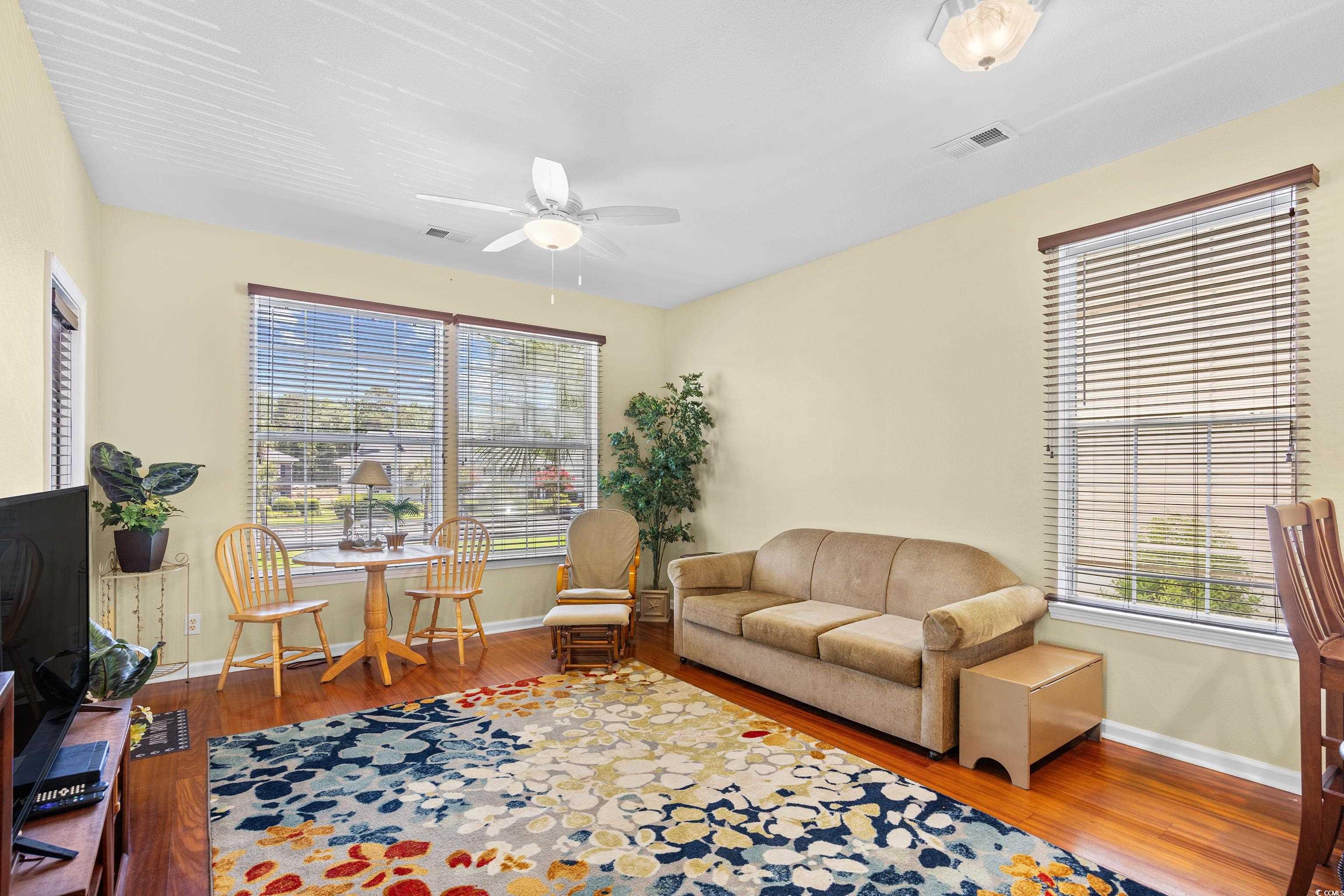 1298 River Oaks Drive, Unit 5J Myrtle Beach, SC 29579 - Photo 9 of 33 Living room with a ceiling fan, wood finished floors, and plenty of natural light