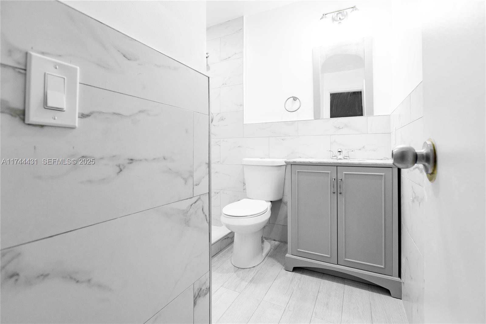 1060 Northeast 78th Street, Unit 5 Miami, FL 33138 - Photo 14 of 17 a bathroom with a toilet sink and mirror