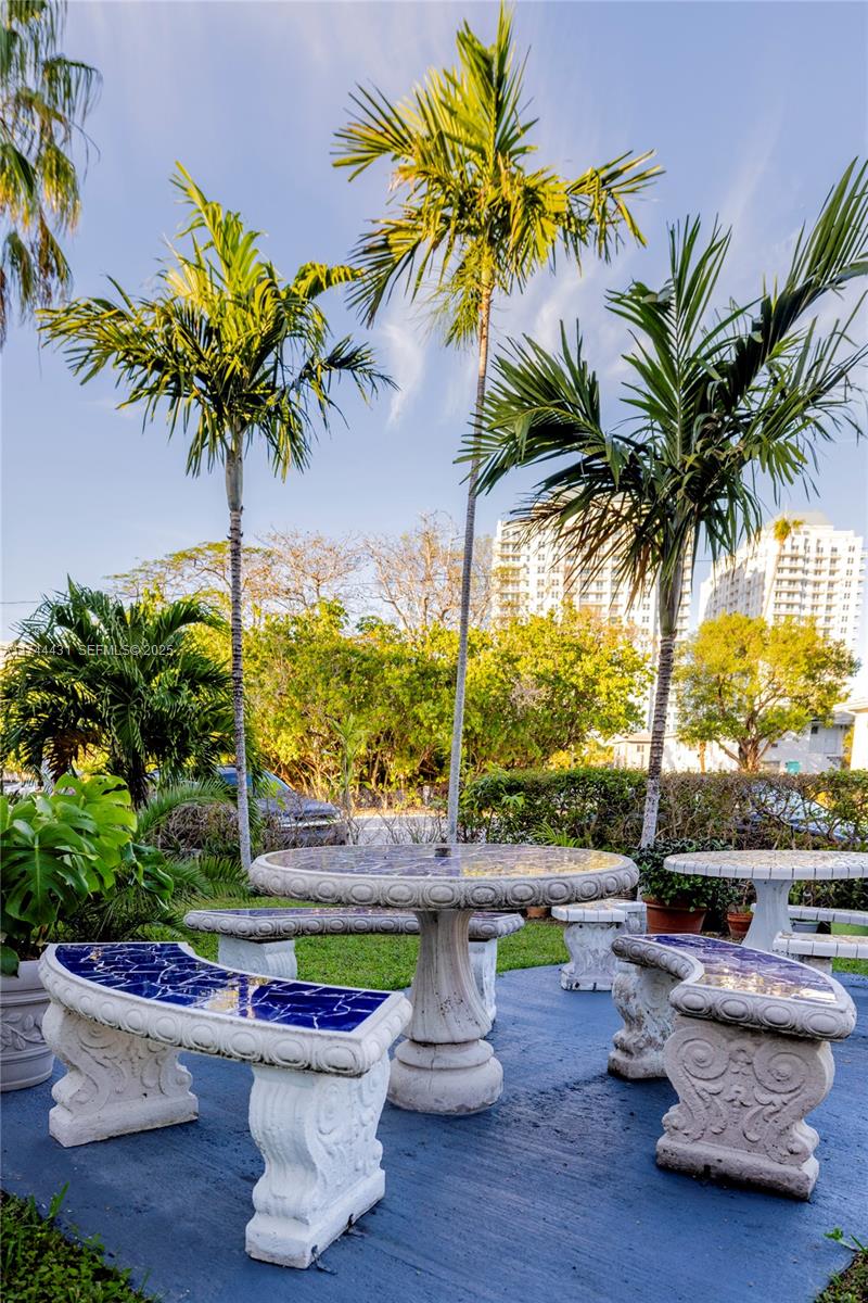 1060 Northeast 78th Street, Unit 5 Miami, FL 33138 - Photo 16 of 17 a swimming pool with outdoor seating and a garden