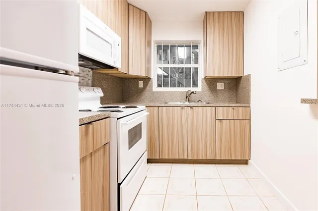 a kitchen with white cabinets and white appliances