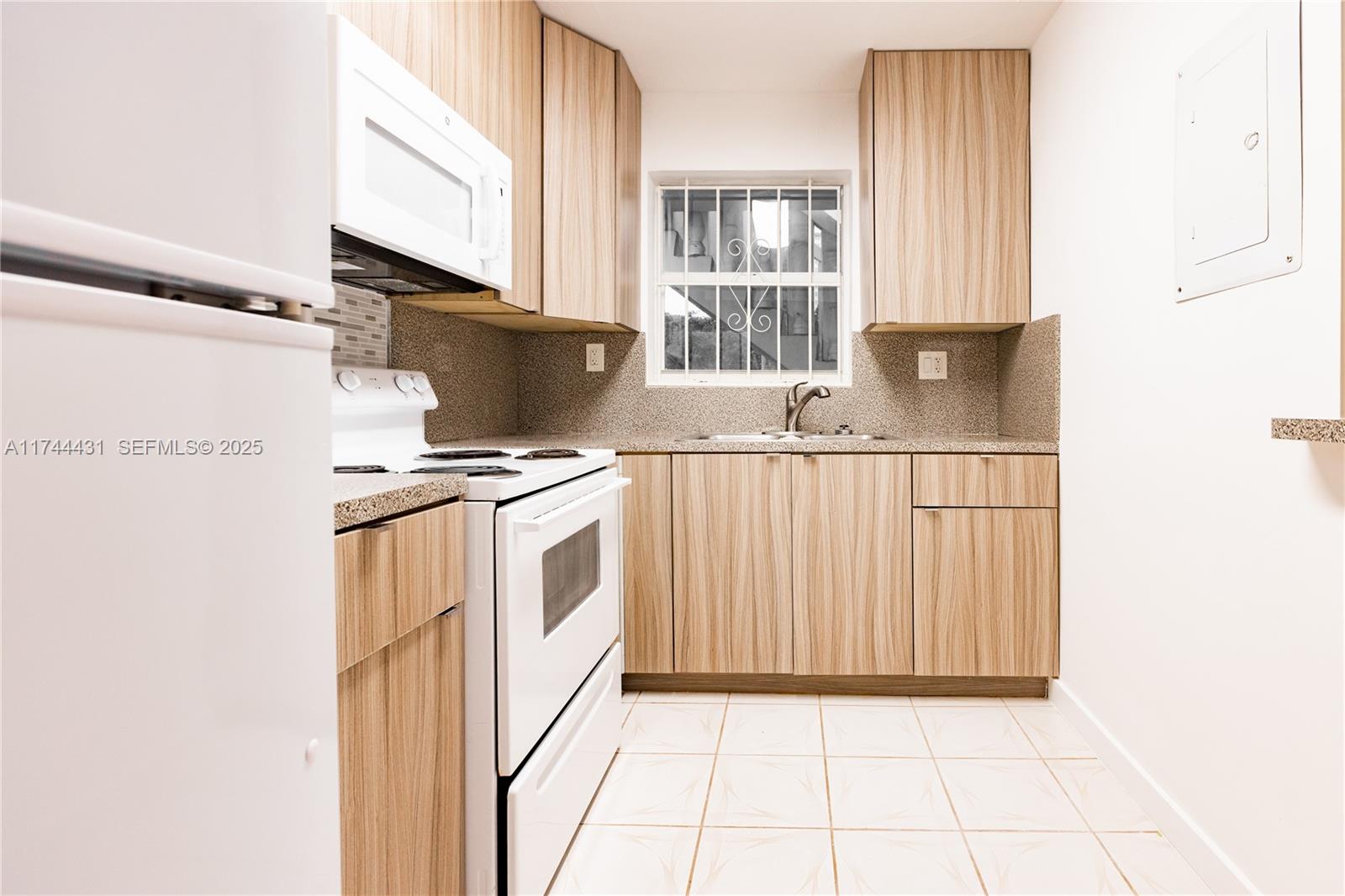 1060 Northeast 78th Street, Unit 5 Miami, FL 33138 - Photo 5 of 17 a kitchen with white cabinets and appliances